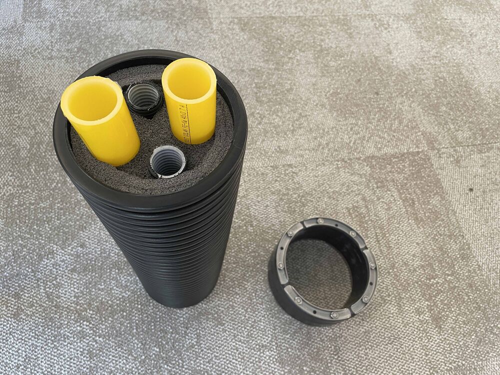 Fernleitung DN160, ausgedämmt (VL/RL je DN40, 2 Elektro-KSR) mit Dichtmanschette für Mauerdurchführung nach Kernbohrung.